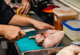 Chef cutting a chicken breast
