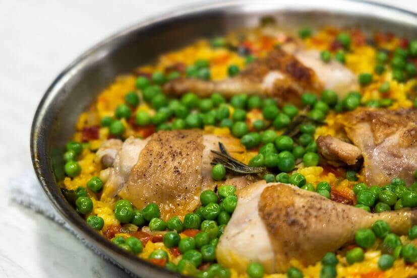 Chicken, peas, and other vegetables in a silver pan