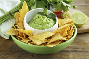 cup with guacamole and corn chips - traditional Mexican appetizer