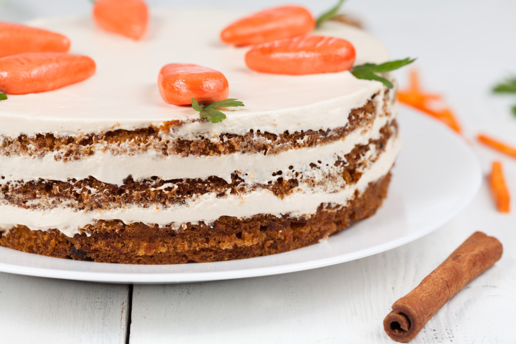 Tasty easter carrot cake with cream and little carrots on